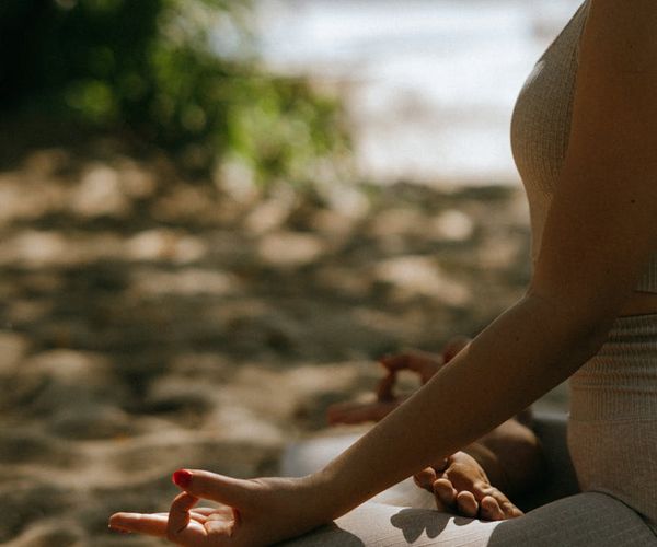 A serene person meditating in a calm natural environment.